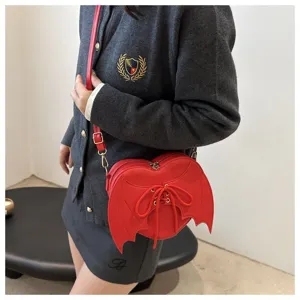 Zijaanzicht van een rode hartvormige crossbodytas met gotische duivelsvleugels