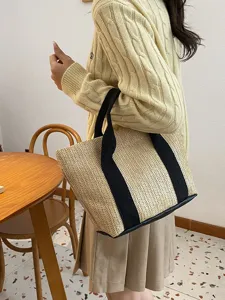 Bolso tote de paja tejida de estilo pastoral llevado por una modelo en interiores