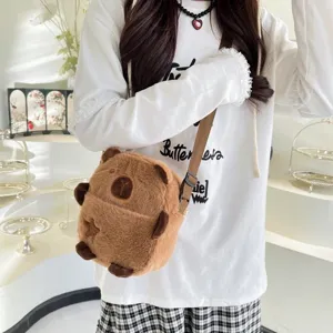 Vue détaillée d'un joli sac à bandoulière en peluche Capybara marron porté par un modèle.