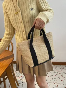 Detalle de cerca de un bolso de paja trenzada con correas de tela negra para el verano