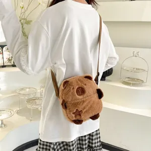 Vue détaillée d'un sac à bandoulière en peluche capybara marron porté à l'épaule