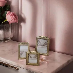 Elegant gold resin photo frames featuring panther accents on a pink marble tabletop