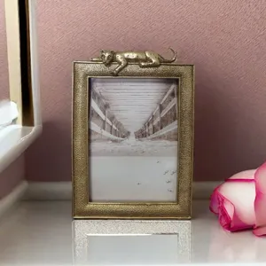 Detailed macro shot of a luxury resin photo frame with a gold leopard figurine on top.