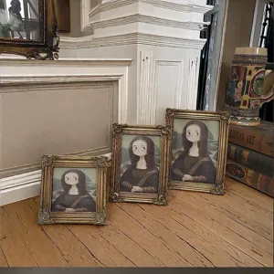Detail view of ornate gold carved resin picture frames in three sizes with Mona Lisa art