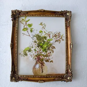 Detailed view of ornate vintage resin picture frame featuring a floral oil painting