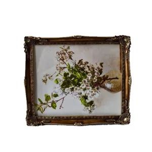 Ornate vintage resin picture frame featuring a classic floral still life painting