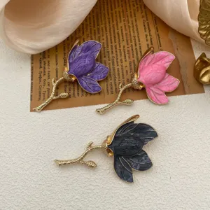 Detailed view of vintage tulip enamel brooches in purple, pink, and grey colors on paper
