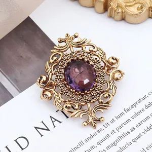 Nahaufnahme einer antiken Goldbrosche mit einem eleganten violetten Edelstein