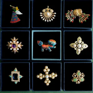 Collection of vintage baroque brooches with pearls and gemstones in display boxes