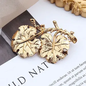 Makroaufnahme einer goldenen Vintage-Blattbrosche mit feiner Aderstruktur