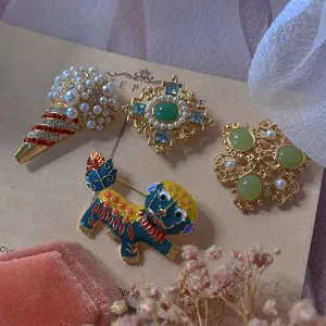 Detailed view of vintage Baroque gemstone brooches featuring animal and geometric designs.