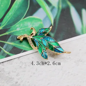 Macro view of a vintage bird brooch with green and blue enamel and shining crystals