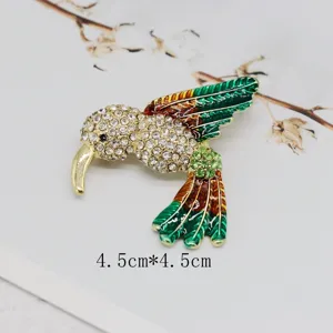 Detailed view of a vintage hummingbird brooch with colorful enamel and rhinestones