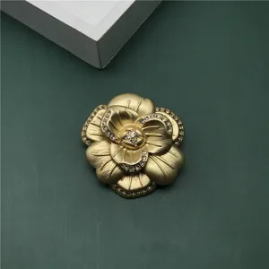 Exquisite golden baroque camellia brooch with sparkling rhinestones and matte metal finish