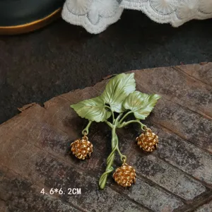 Detailed view of a vintage lily of the valley brooch with green enamel leaves.