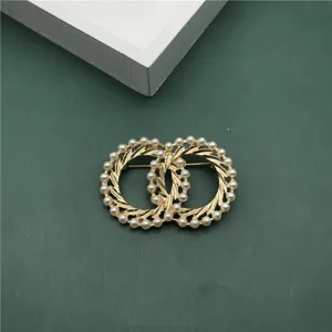 Detailed macro view of a vintage Baroque style gold brooch featuring elegant pearl embellishments