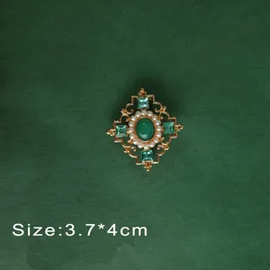 Detailed view of a vintage baroque green gemstone brooch with pearls