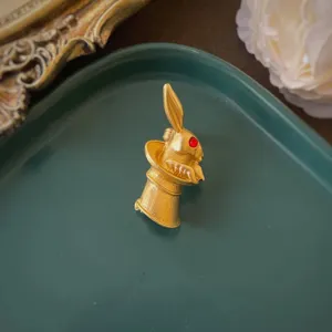 Dettaglio di una spilla barocca vintage a forma di coniglio nel cappello dorato con occhio
