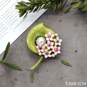 Gedetailleerde close-up van een vintage broche in bosstijl met roze bloemen en parels
