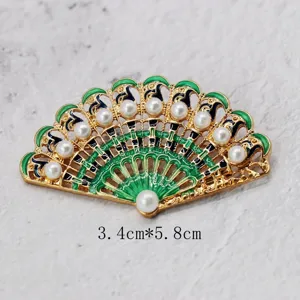 Detailed macro view of a vintage green enamel fan brooch with pearls, 3.4cm x 5.8cm