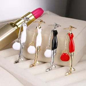 Close-up of elegant enamel lady brooches in various colors displayed on jewelry box.