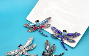 Detailed view of colorful vintage-style dragonfly brooches encrusted with sparkling rhinestones.