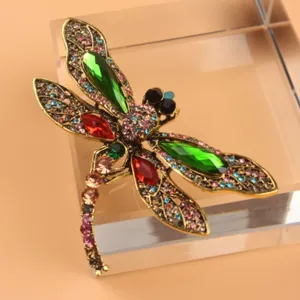 Vintage gold-toned dragonfly brooch with vibrant multi-color rhinestones for coat accents.