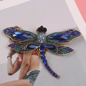 Elegant vintage dragonfly brooch featuring large blue crystals and teal rhinestones