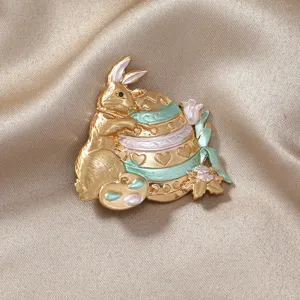 Élégante broche lapin vintage en or mat avec détail d'œuf de Pâques émaillé