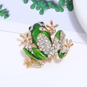 Prachtig detail van een sprankelende kikkerbroche van groen emaille met kristallen