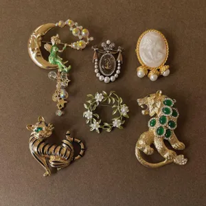 Detailed view of assorted vintage Baroque brooches including fairy and lion designs
