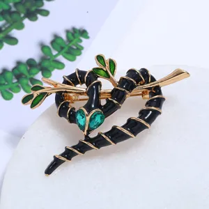 Macrodetail van de groene kristallen en zwart emaille op de broche in de vorm van een slang