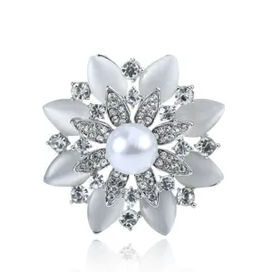 Detailed view of luxury floral brooch featuring central pearl and cat's eye stones