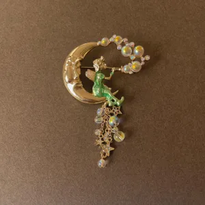 Detailed view of a vintage Baroque fairy brooch with crescent moon and iridescent tassels