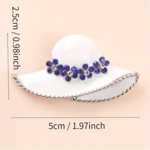 Close-up detail of a white enamel hat brooch decorated with blue rhinestones and dimensions