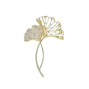 Elegante gouden ginkgobladbroche met fonkelende kristallen op wit