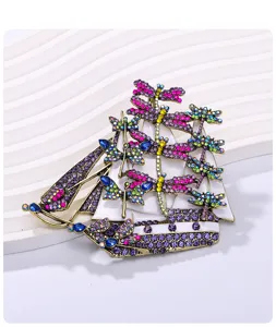 Close-up detail of a vintage dragonfly sailboat brooch with vibrant colorful rhinestones