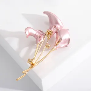 Detailed macro view of an elegant pink enamel calla lily flower brooch with gold finish