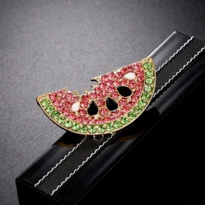 Close-up of watermelon crystal drip oil brooch pin with sparkling pink and green rhinestones