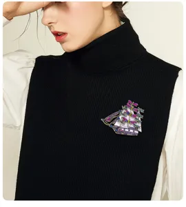 Vintage sailboat brooch with colorful rhinestones and dragonfly motifs on model.