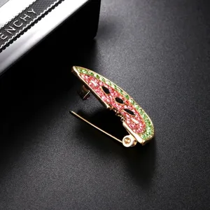 Close-up of watermelon brooch featuring pink and green crystals with gold alloy base