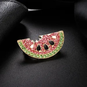 Macro view of a bitten watermelon slice brooch adorned with sparkling pink and green rhinestones