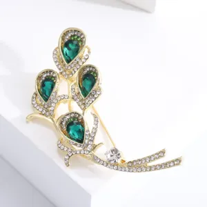 Detailed view of vintage gold calla lily brooch with emerald green gemstones