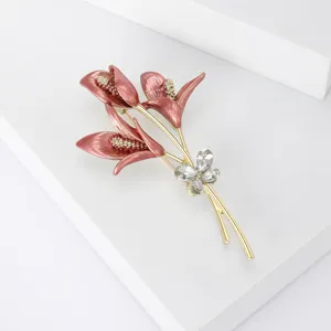 Vista de detalle de broche de lirio esmaltado en rosa vintage con pedrería brillante