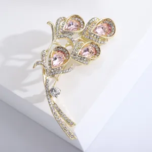 Exquisite close-up of gold calla lily brooch with shimmering pink crystal droplets