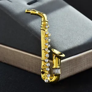 Macro detail of a golden saxophone brooch pin inlaid with glittering clear rhinestones