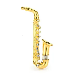 Elegant golden saxophone instrument brooch encrusted with sparkling clear rhinestones