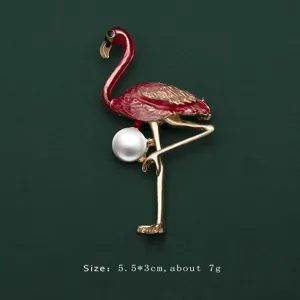 Detailed view of an elegant red flamingo enamel brooch with white pearl accent on dark green
