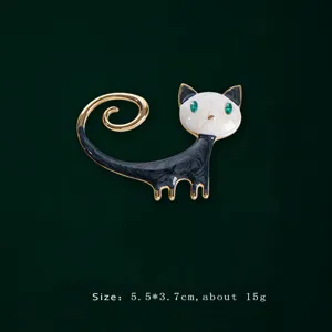 Elegant black and white enamel cat brooch with green eyes and gold-tone finish.