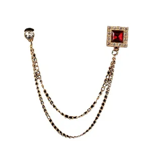 Elegante spilla a catena dorata con rubino rosso quadrato e accenti di cristallo scintillanti